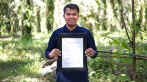 A smallholder farmer receives his certificate from the ISPO Secretariat 一位小农收到ISPO秘书处颁发的证书